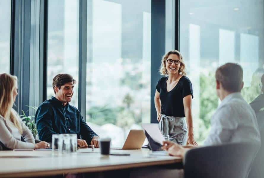 Smiling employees experiencing rapid growth talk about business management in a conference room