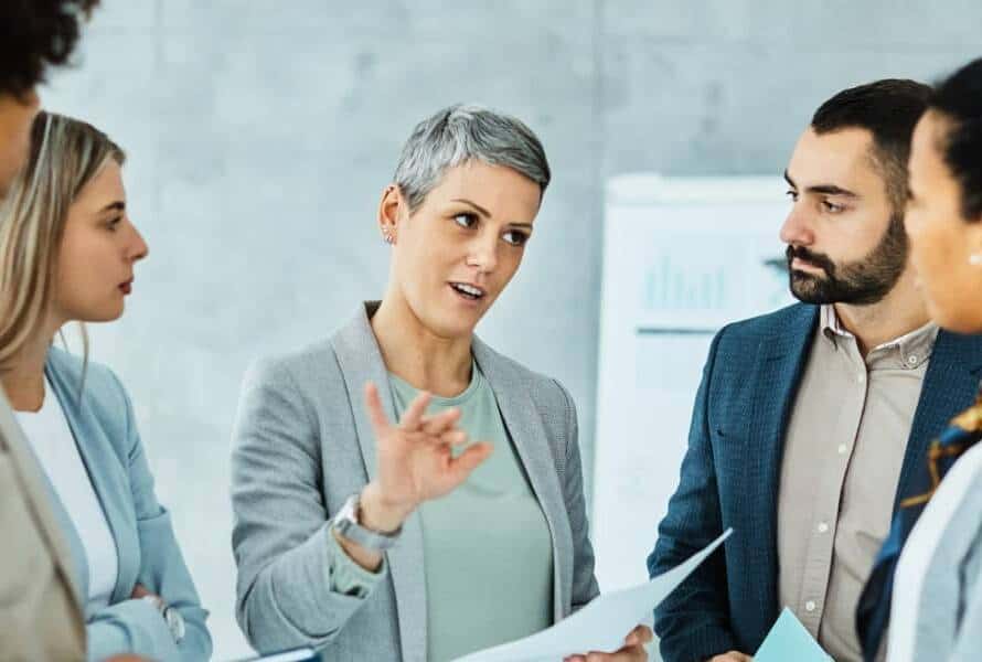 A professional woman explaining a concept to a team of employees